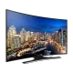 Samsung 55HU7200 Ultra HD 4K LED televizyon; şehir manzarası ekranında siyah renkli TV standı ile.