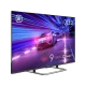 Arçelik A 955 C AI Ultra HD 4K QLED TV, siyah çerçeveli ekranda neon ışıklı yarış sahnesi gösteriyor